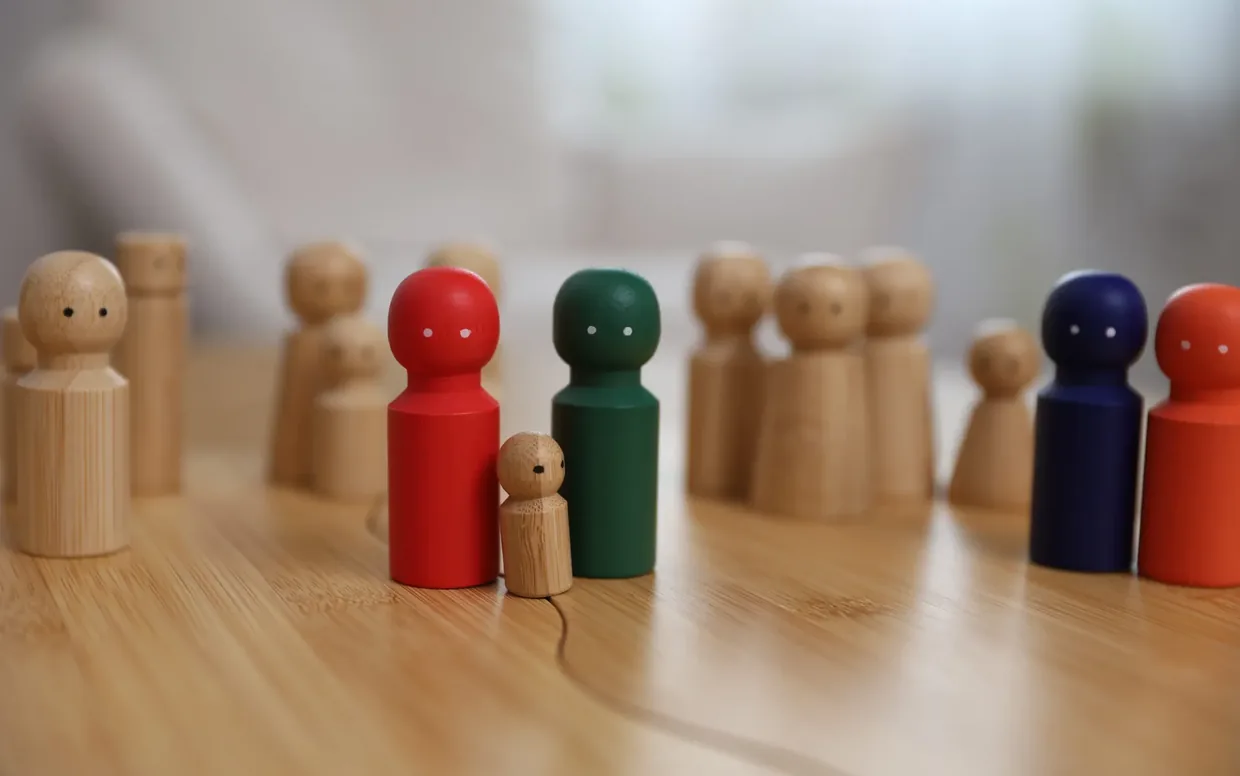 Systemische Holzfiguren – ein Kind unter Erwachsenen